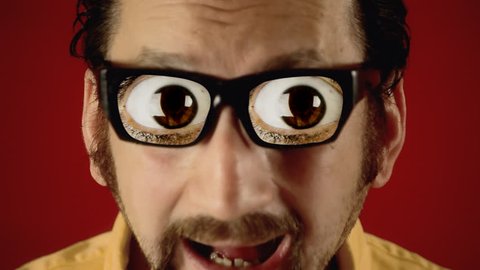 A funny ugly man with hypnotic glasses, looking at a flickering neon sign over a wall, with the text Sex. A pair of popping eyes appears soon after.

