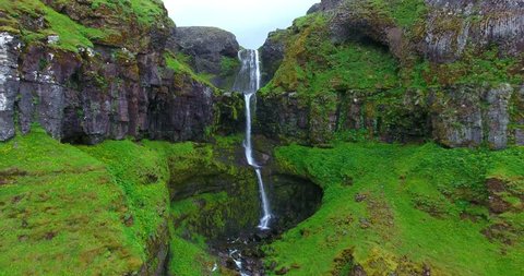 Green Valley Cliffs With Waterfall - Aerial Footage of the Kvernufoss Falls in Iceland