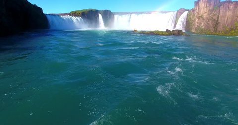 Horseshoe Waterfall With Rainbow Emptying into Wide Blue River - Godafoss Falls in Iceland