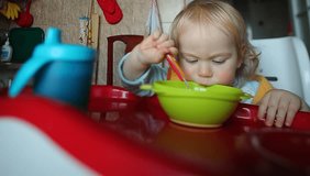 Video baby eats sitting at the table