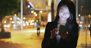 Business woman looking at smart phone in the city