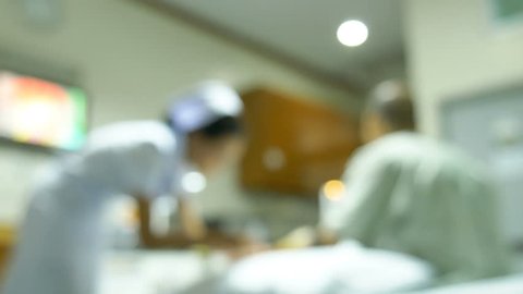 Defocus of nurse checking asian patient health in hospital