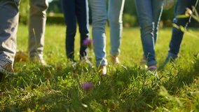 Close up of adult and children legs promenading on grass