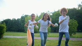 Radiant young environmentalists running with excitement after cleaning in park