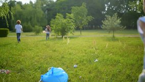 Energetic young volunteers running in park while cleaning garbage there