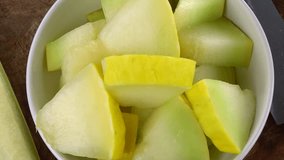 Portion of Honeydew Melon rotating on a wooden plate (not loopale; 4K)