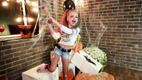 having fun at halloween party, harley quinn threatens with baseball bat, happy little girl, 