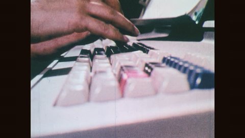 1970s: Fingers typing on keyboards. Woman works on early computer.