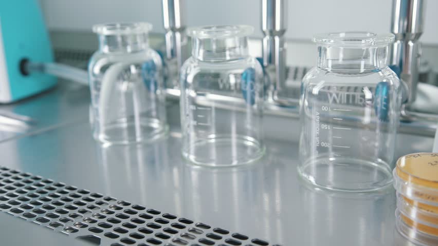 Laboratory equipment and lab assistant's work: hands of the scientist in sterile blue gloves are prepared by catalysts and test systems.  | Shutterstock HD Video #29197501