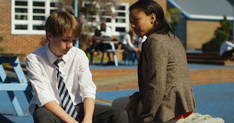4k, A concerned teacher talking to a young boy teased at school. Slow motion