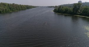 Ukraine. Kiev. July 25, 2017. Truhanov Island. Aerial. 4K video. River Dnieper. Summer. Sunny weather. Kayaks. Water. People. Sport. Training. Two guys row oars in a canoe. Trees. Competition.