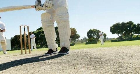 Batsman playing a defensive stroke during match on cricket field