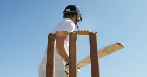 Batsman getting bowled during match on cricket field