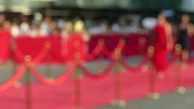 Blurred video. Red carpet entrance with golden stanchions and ropes. Celebrity nominees go to the premiere. Stars on the festive awarding of prizes awards