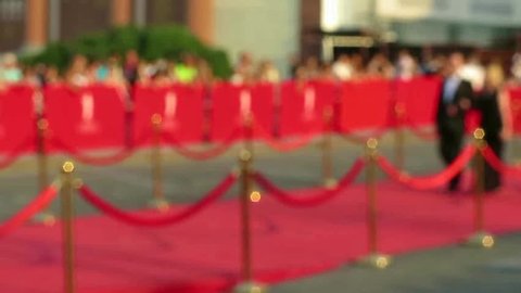 Blurred video. Red carpet entrance with golden stanchions and ropes. Celebrity nominees go to the premiere. Stars on the festive awarding of prizes awards