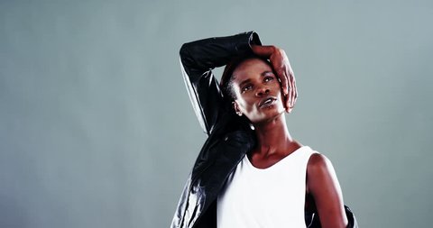Confident androgynous man posing against colored background