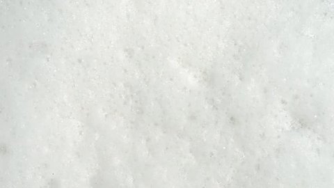 white foam bubbles at the washing machine, close up top view for your background
