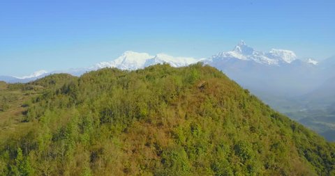 Aerial drone rising, twisting view of Annapurna Himalaya mountain range seen from high elevation at Sarangkot viewpoint on clear summer morning in Nepal. 4k 1.9:1 23.976fps