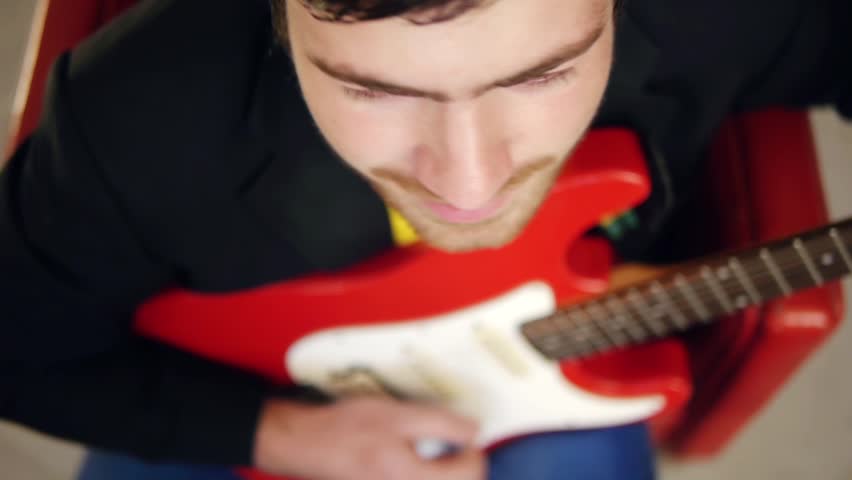 Above view of musician playing song on electric guitar