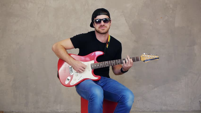 Musician sitting and playing solo on guitar