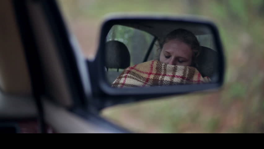 Pretty woman with blanket wake-up in car