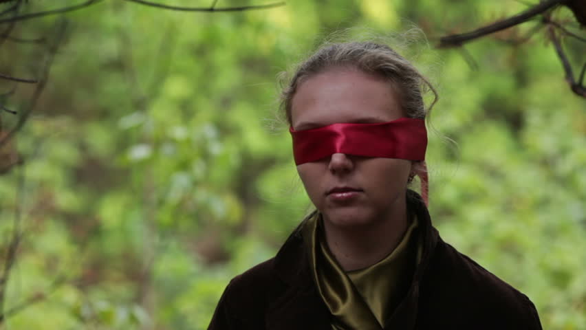 Woman with red blindfold in forest