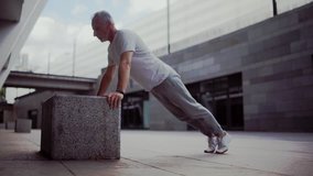 Senior man doing push ups outdoors