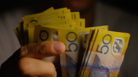 Male hands counting $50 notes in Australian dollars