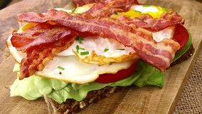 Bacon with fried Eggs (rotating on a wooden plate; seamless loopable; 4K)