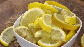 Sliced Lemons rotating on a wooden plate as seamless loopable 4K UHD footage