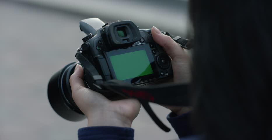 Hand holding digital camera rear view. Empty space for your picture or text. Girl holding a camera