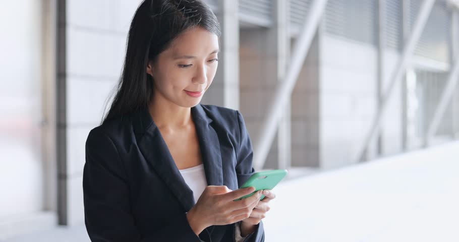 Business woman working on mobile phone at outdoor 