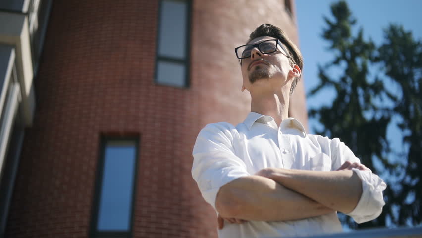 Couple woman man outdoor brick wall background standing crossed arms hands confident thinking keeping silent looking each other smiling around view below keep success satisfied attractive partners
