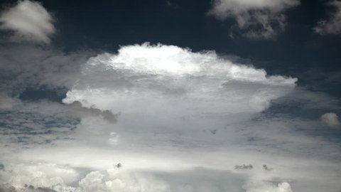 Time Lapse, Striking, sunlit monsoon anvil cloud rises like spaceship amid swirling darker clouds, blue sky. 4K UHD 3840x2160
