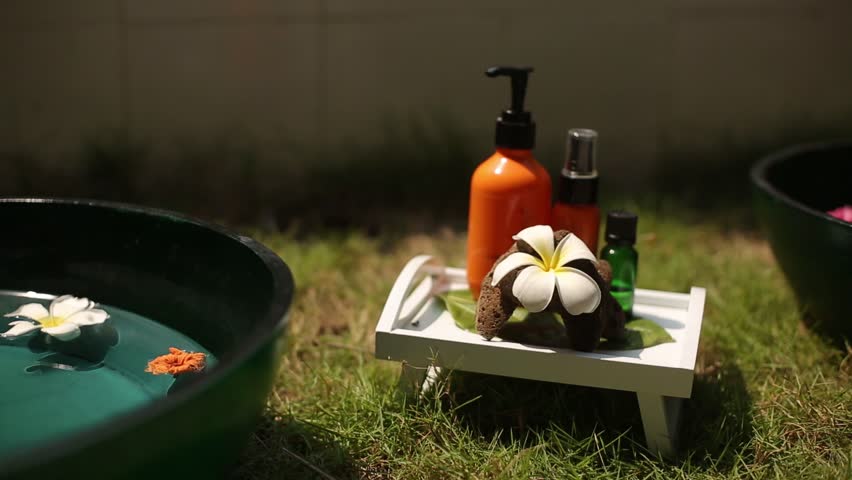 Spa accessories and decor: moisturizer, oils, candles, towels, flowers at tropical island spa therapy center on Maldives