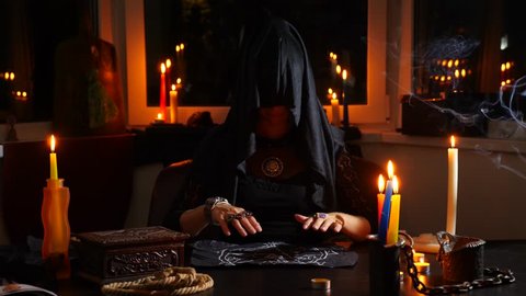The witch is a fortune teller with candles close-up. A magical ritual. divination. Halloween, 4k, slow-motion