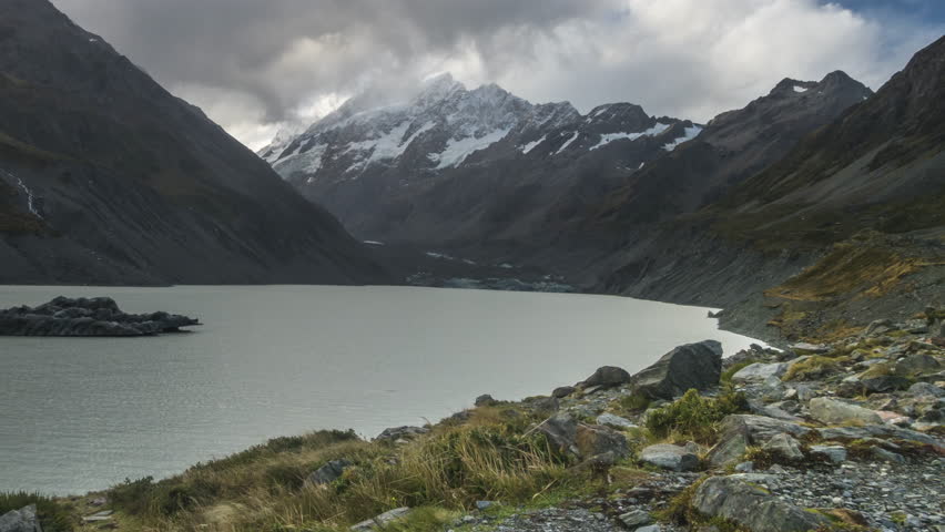 Time Lapse - Clouds moving at Mount Cook with Hooker Lake as foreground. Captured during rain, water droplets on lens. Camera pan left.