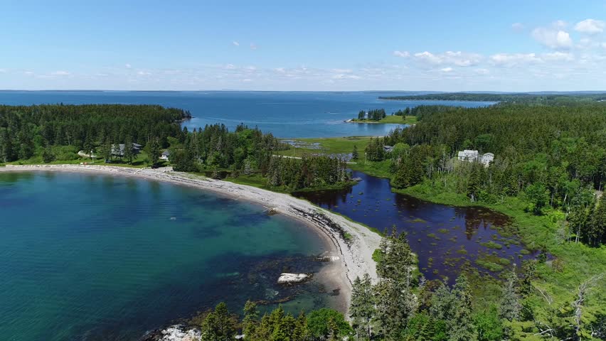 A moving aerial view along the Bernard shoreline within Bass Harbor on Mt Desert Island Maine