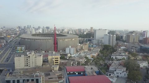 Aerial shot of Perú's national stadium with waving peruvian flag. Lima, Perú.
