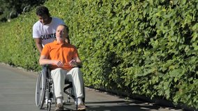Helpful hindu volunteer walking with a wheelchaired man