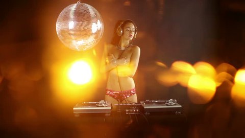 a sexy female dj dancing topless and playing records