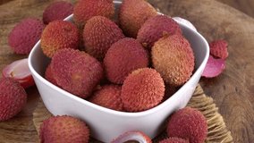 Lychees rotating on a wooden plate (not loopable; 4K)