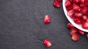 Pomegranate Seeds rotating on a wooden plate as seamless loopable 4K UHD footage