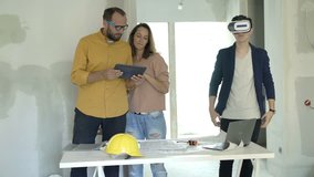 Family with vr goggle and tablet watching virtual project at their new home 
