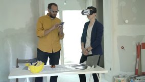 Father and son with vr goggle and smartphone watching virtual project at new home 
