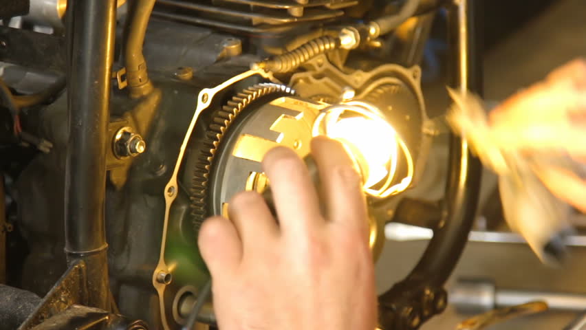 A hand of motorcycle mechanic assembling clutch assembly using light. Royalty-Free Stock Footage #29270092