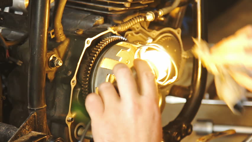 A hand of motorcycle mechanic assembling clutch assembly using light. Royalty-Free Stock Footage #29270095