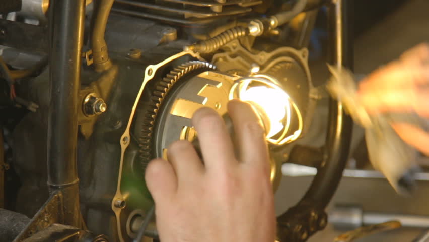 A hand of motorcycle mechanic assembling clutch assembly using light. Raw ungraded. Royalty-Free Stock Footage #29270098