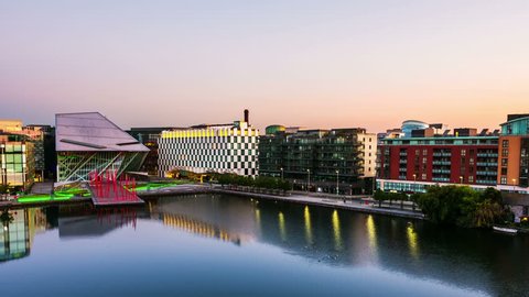 Dublin, Ireland. Aerial view of Grand Canal docks in Dublin, Ireland at sunrise. Empty streets and illuminated modern buildings, colorful clear sky. Time-lapse from night to day