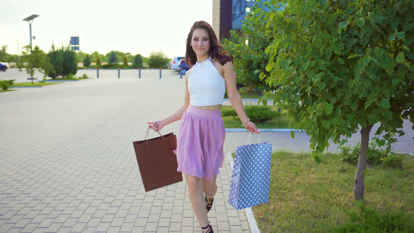 Young handsome woman is dancing after shopping holding shopping bags near mall Royalty-Free Stock Footage #29272858